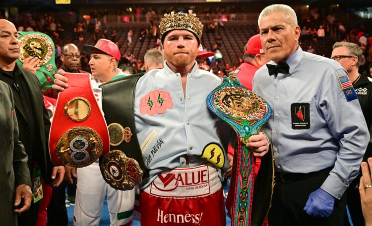 Canelo Alvarez poses with title belts