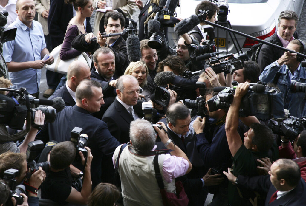 McLaren boss Ron Dennis walks through a sea of journalists with cameras and microphones ahead of the 'spygate' scandal hearing