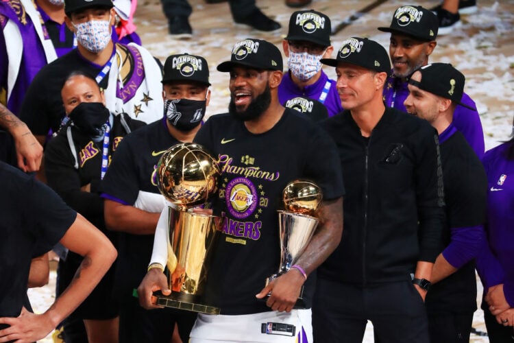 LeBron James #23 of the Los Angeles Lakers reacts with his MVP trophy and Finals trophy