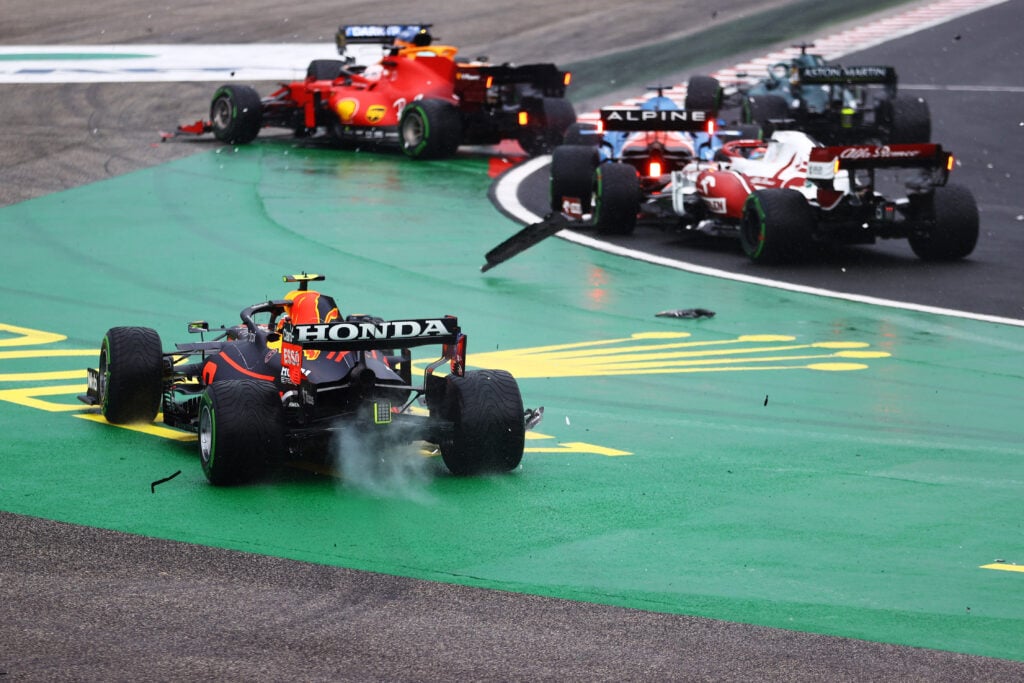 Sergio Perez of Mexico driving the (11) Red Bull Racing RB16B Honda runs wide at the start