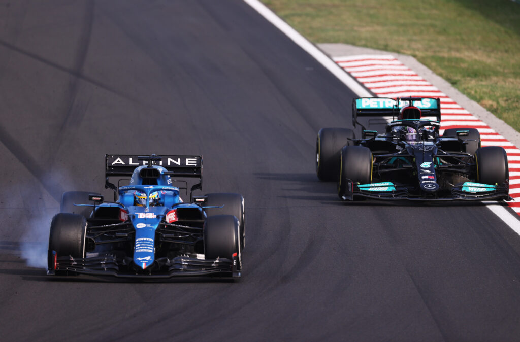 Fernando Alonso of Spain driving the (14) Alpine A521 Renault locks a wheel under braking as he defends from Lewis Hamilton