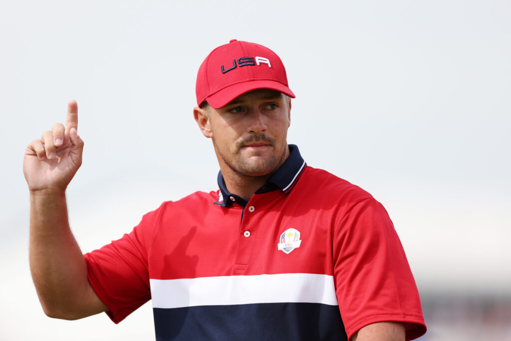 Bryson DeChambeau of team United States points upwards