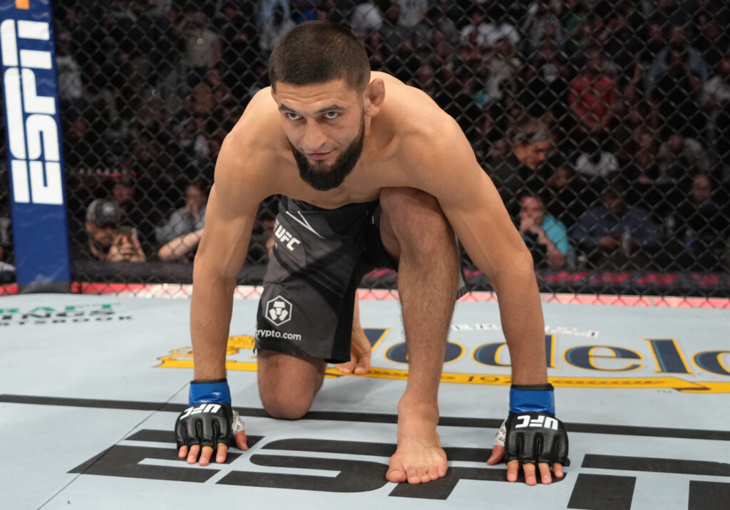 Khamzat Chimaev kneels on the floor before Gilbert Burns fight