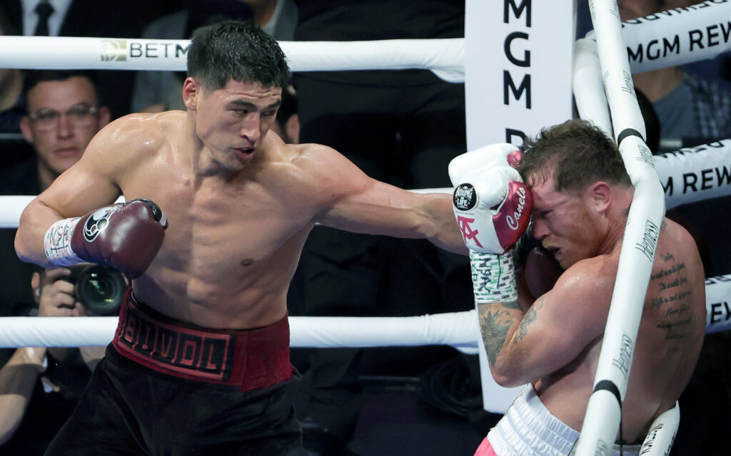Dmitry Bivol (L) throws a left at Canelo Alvarez