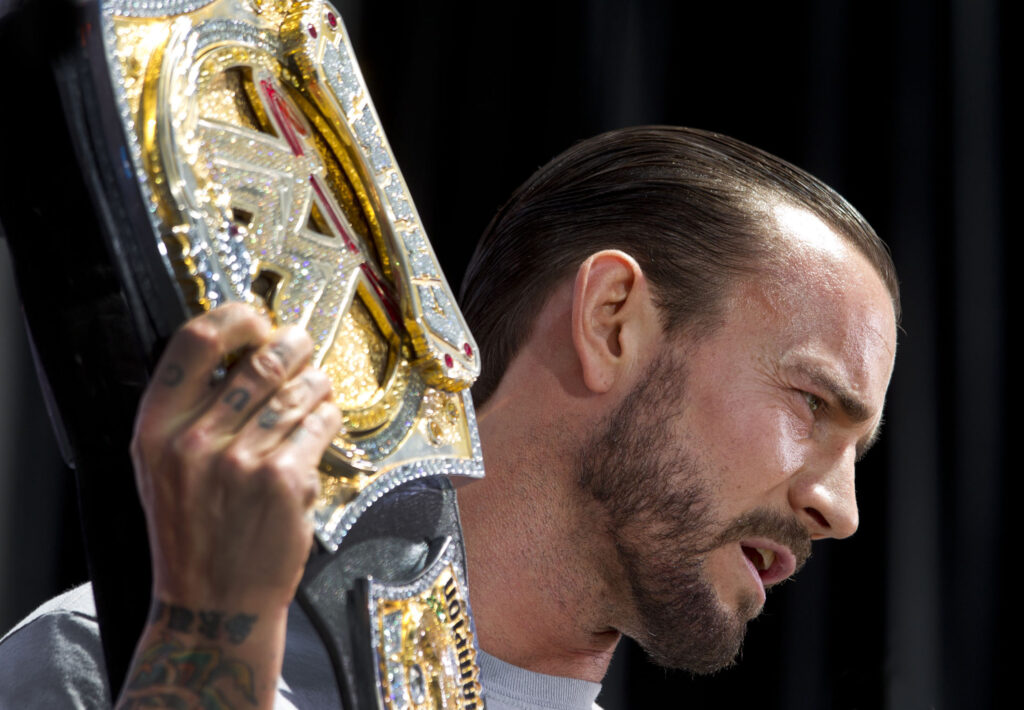 CM Punk showing off the WWE Championship at Wrestlemania 28