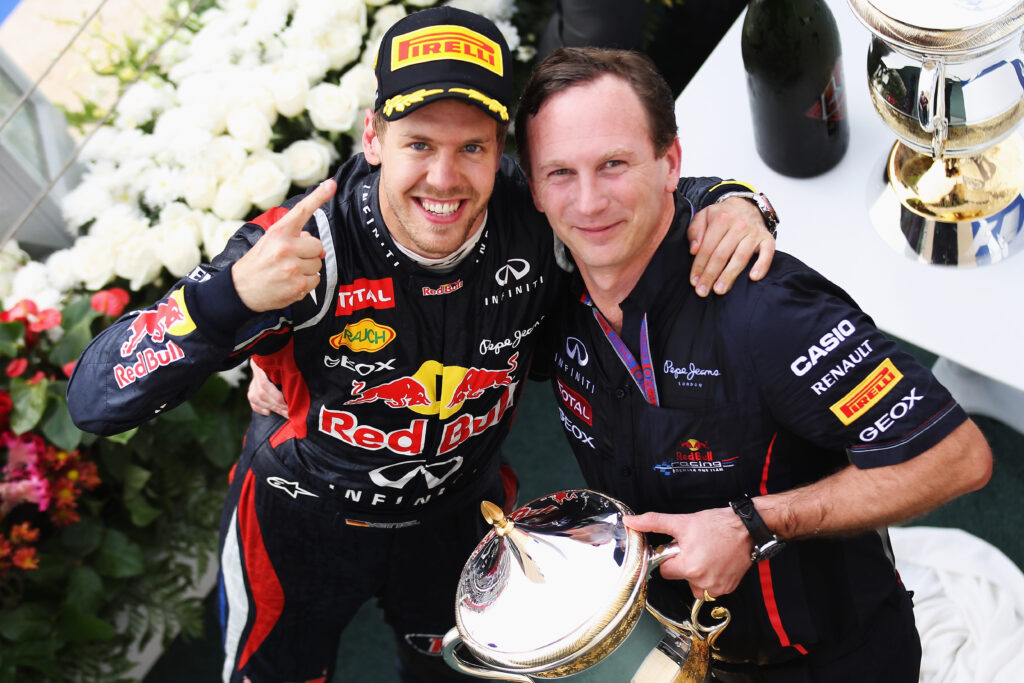 Sebastian Vettel (L) of Germany and Red Bull Racing celebrates on the podium with his Team Principal Christian Horner