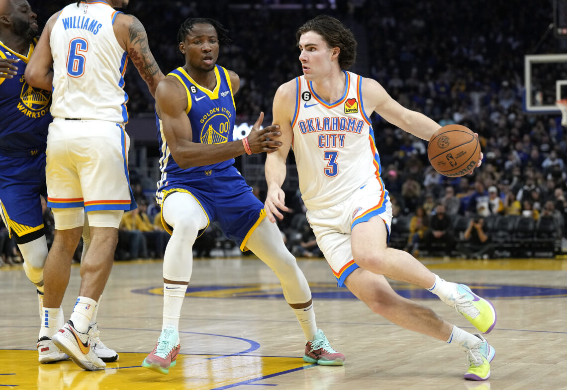 Josh Giddey #3 of the Oklahoma City Thunder drives to the basket on Jonathan Kuminga #00 of the Golden State Warriors