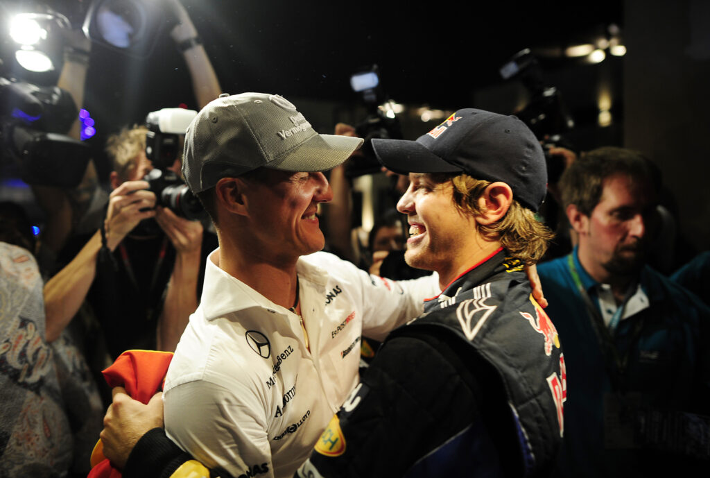 Michael Schumacher embraces Sebastian Vettel after the Red Bull driver wins the 2010 Formula 1 World Championship.