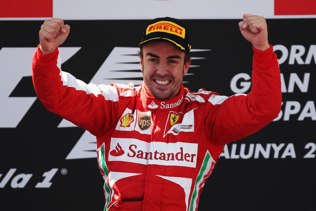 Ferrari's Fernando Alonso celebrates on the podium after winning the 2013 Spanish Grand Prix.