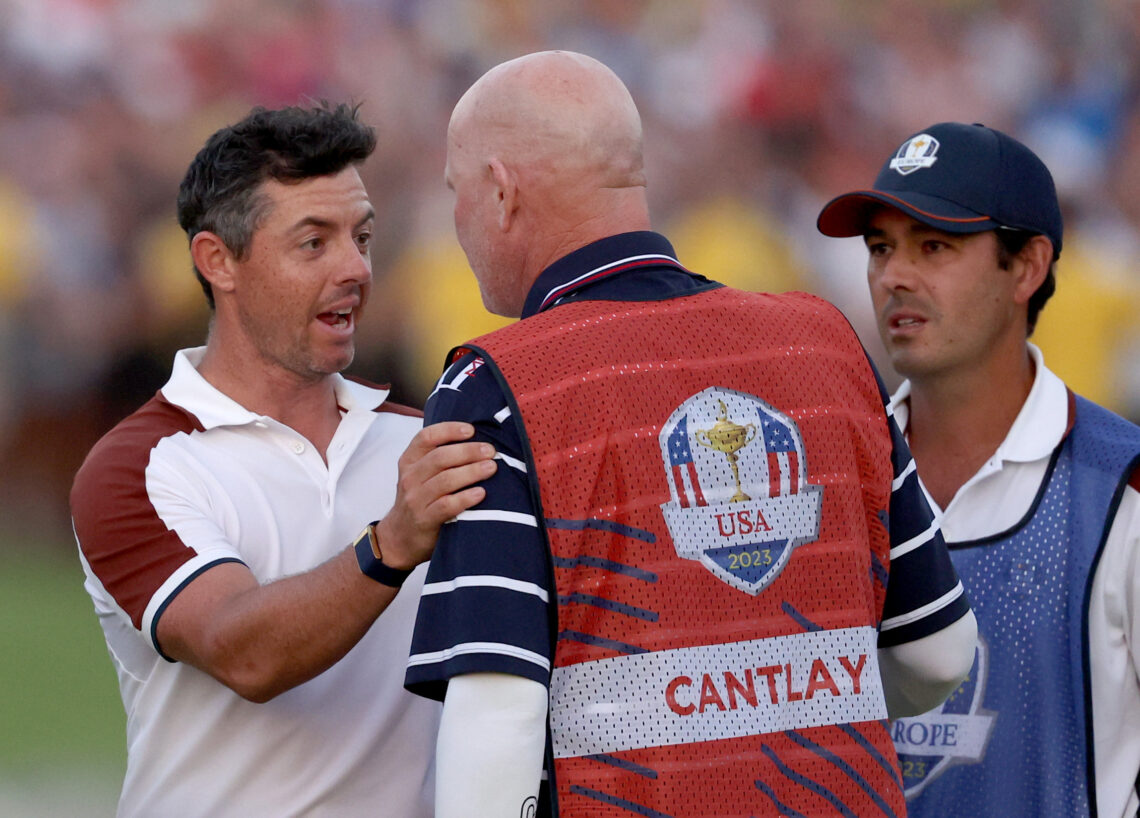 Rory McIlroy of Team Europe speaks with caddie of Patrick Cantlay of Team United States Joe LaCava