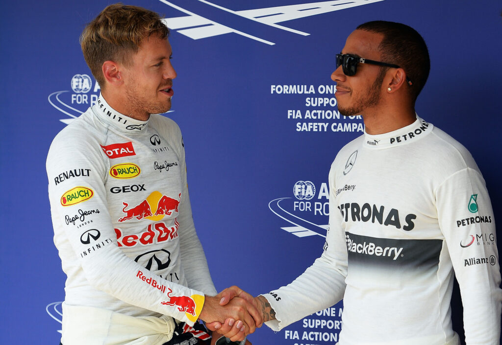 Red Bull Racing driver Sebastian Vettel (left) shaking hands with Mercedes driver Lewis Hamilton (right) at the 2013 Hungarian Grand Prix