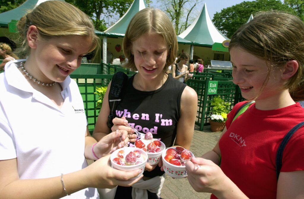 Young spectators at Wimbledon enjoy the traditional strawberries