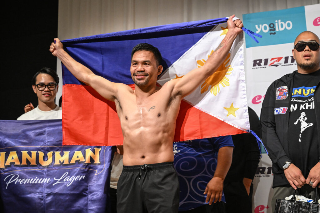 Manny Pacquiao poses with the Philippines flag following the official weigh-in