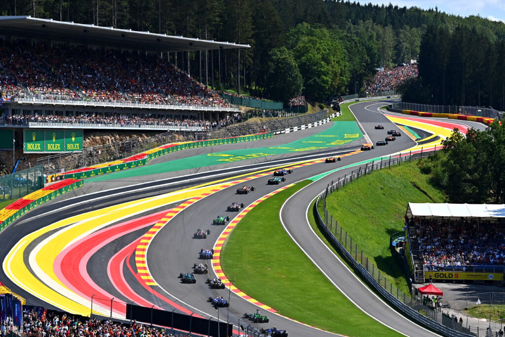 A wide view of the F1 field driving through Eau Rouge at Spa