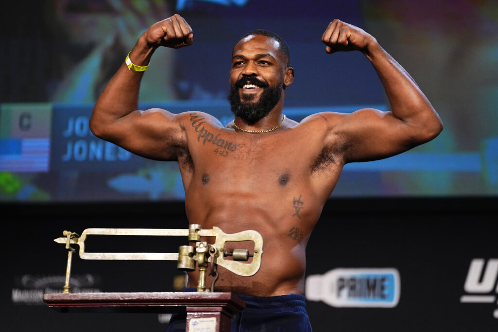 Jon Jones poses on the scales at the UFC 309 weigh-ins