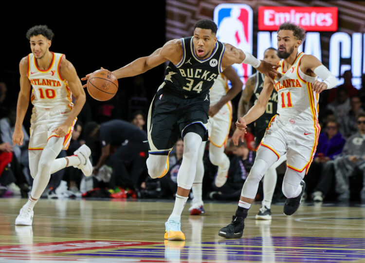 Giannis Antetokounmpo #34 of the Milwaukee Bucks brings the ball up the court against Trae Young #11 of the Atlanta Hawks