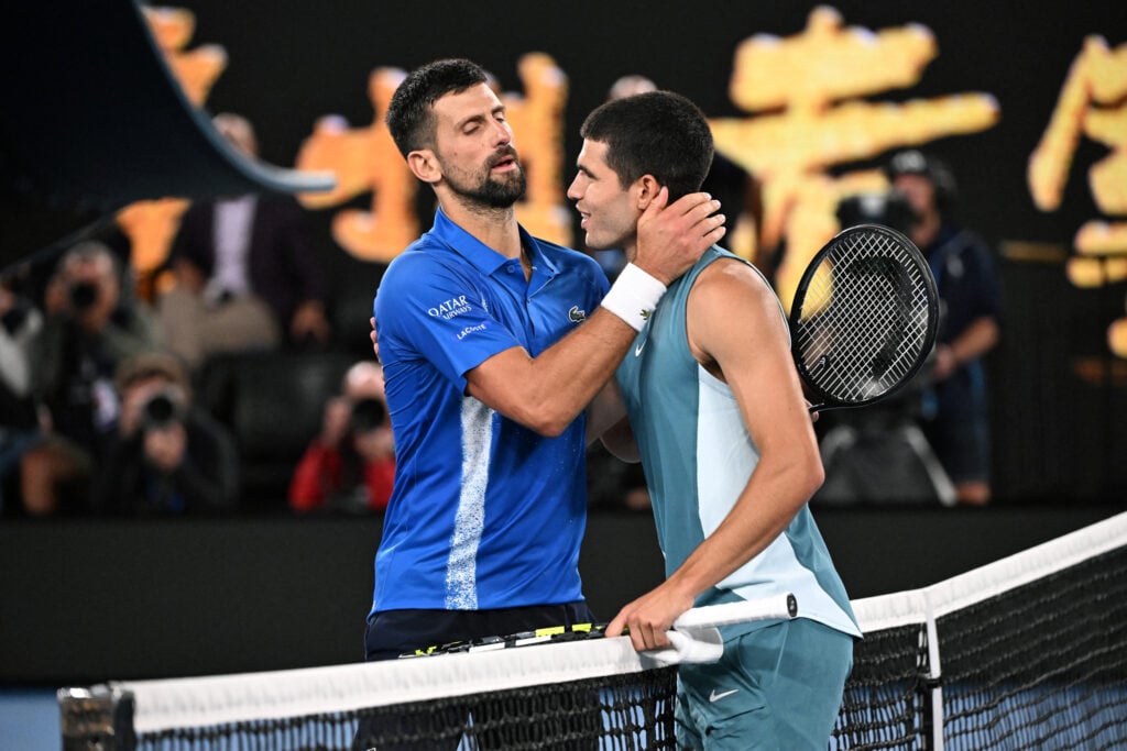 Carlos Alcaraz and Novak Djokovic embracing at the net during the 2025 Australian Open