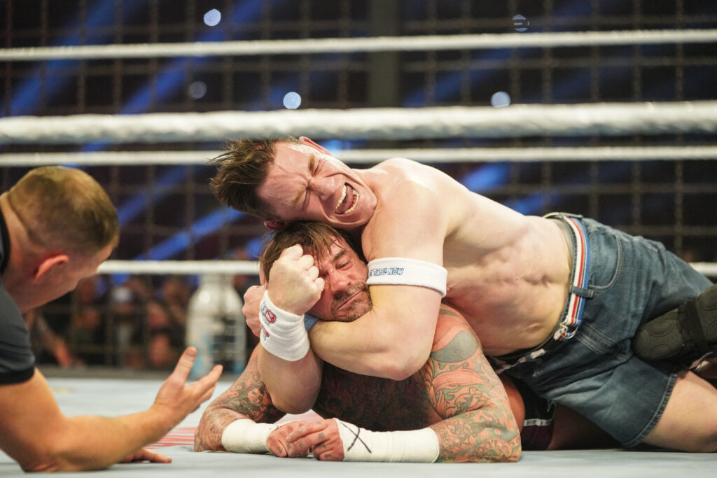 John Cena locking in the STF on CM Punk at the WWE Elimination Chamber in 2025