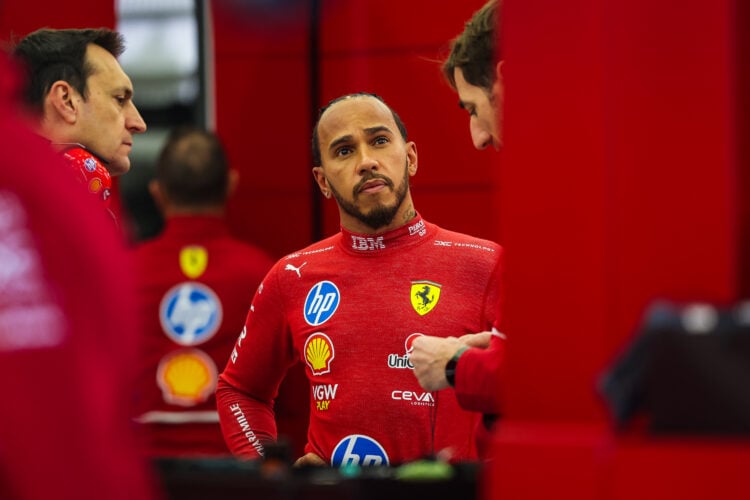 Lewis Hamilton of Great Britain and Ferrari talks to his engineers in the garage