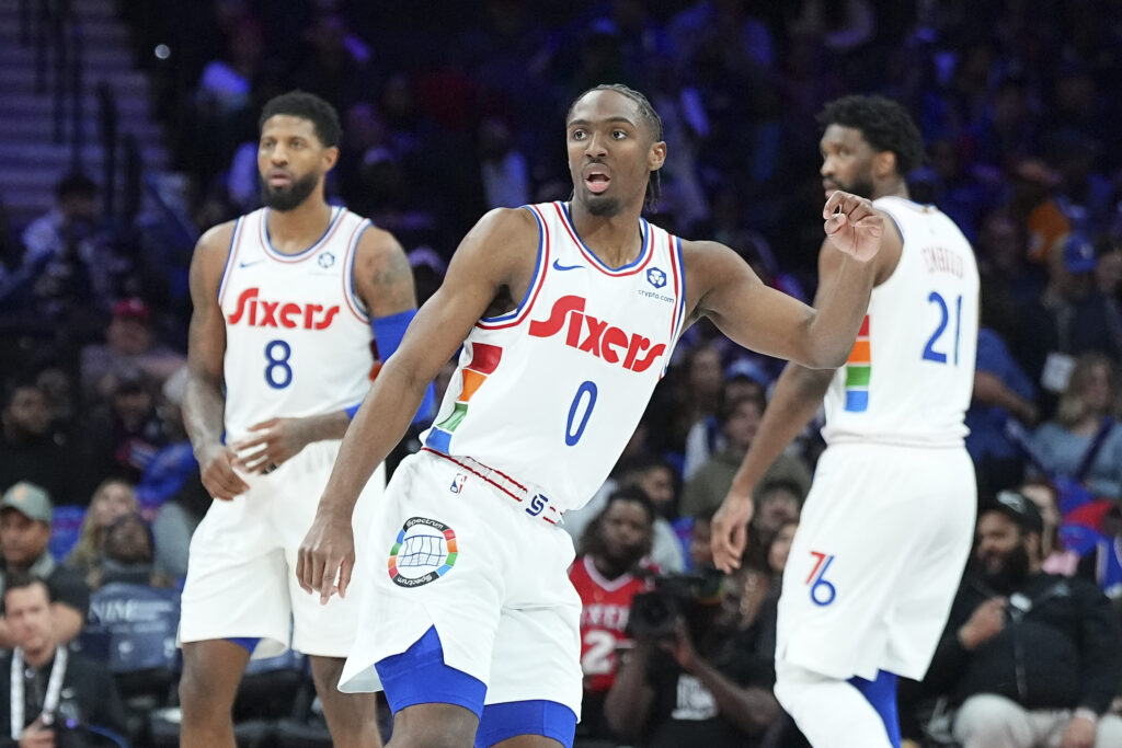 Tyrese Maxey #0, Paul George #8, and Joel Embiid #21 of the Philadelphia 76ers look on against the Toronto Raptors.