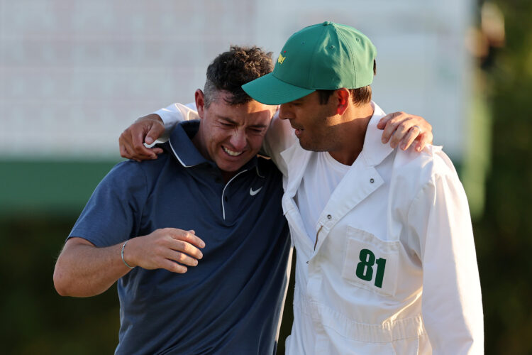 Rory McIlroy of Northern Ireland celebrates winning the 2025 Masters with caddie Harry Diamond