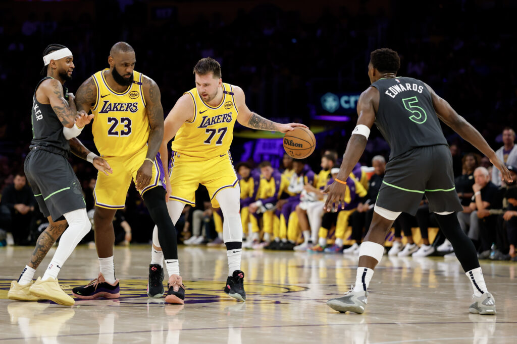 Luka Doncic #77 of the Los Angeles Lakers dribbles the ball against Anthony Edwards #5 of the Minnesota Timberwolves
