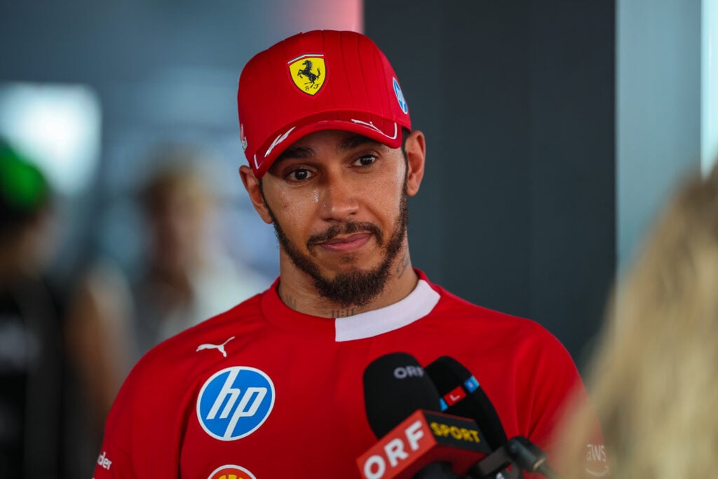 Lewis Hamilton of Great Britain and Ferrari answers questions in the media pen during the F1 Grand Prix