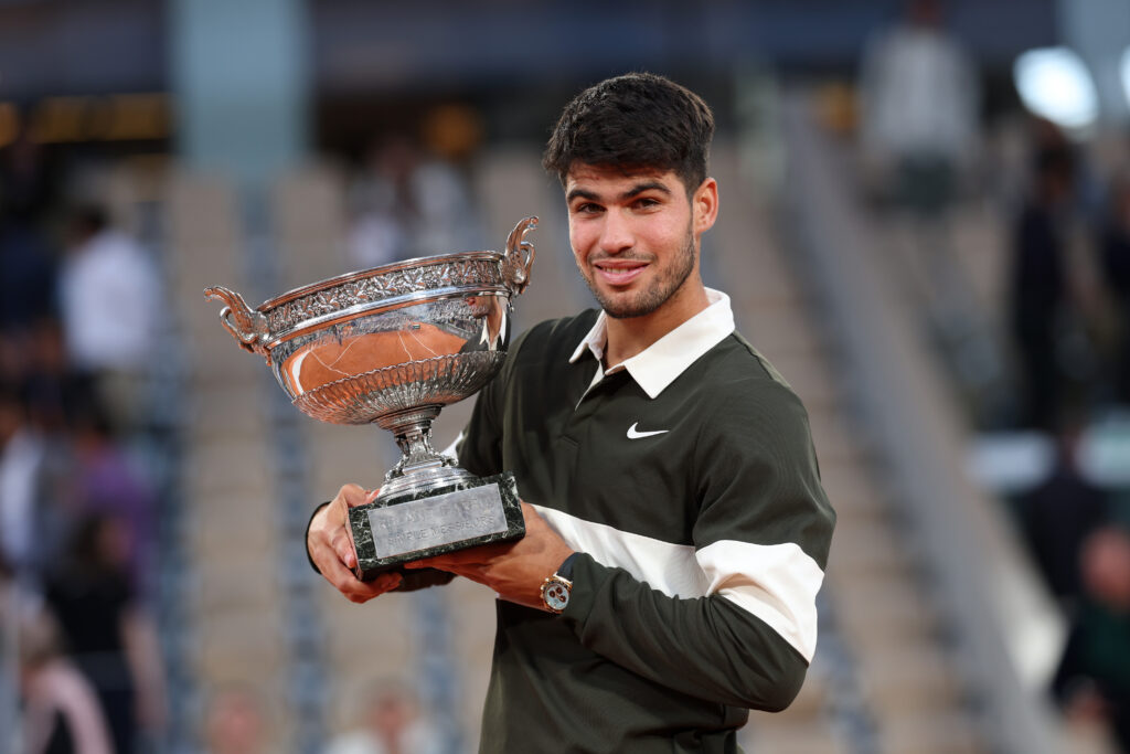 Carlos Alcaraz lifting 2025 French Open trophy at Roland Garros in 2025