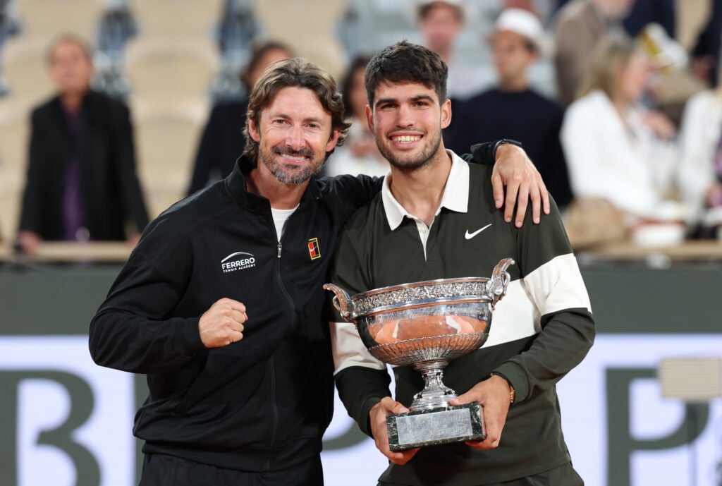 Carlos Alcaraz and Juan Carlos Ferrero posing with the Roland Garros trophy in 2025