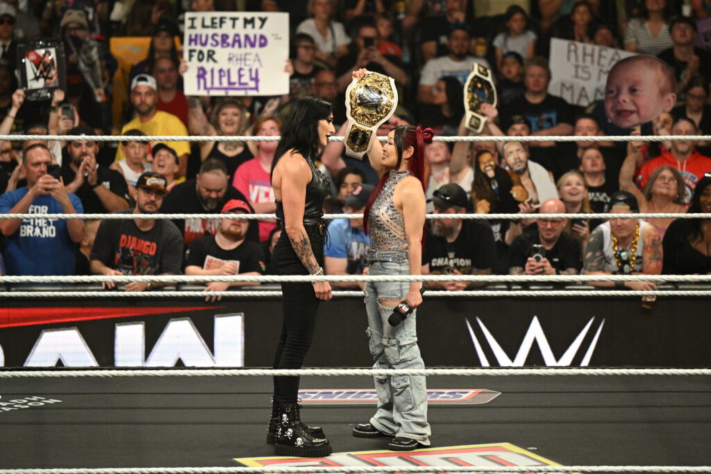 Iyo Sky holding the Women's World Heavyweight Championship in Rhea Ripley's face on WWE Monday Night RAW
