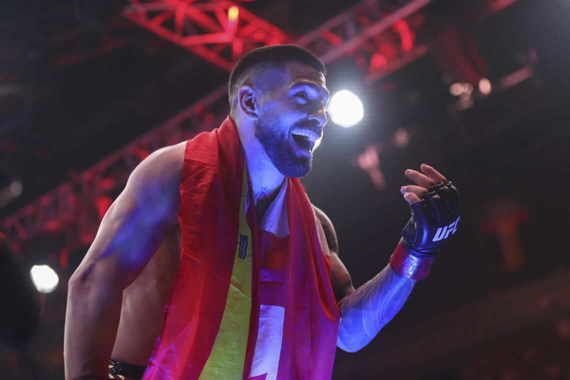 Ilia Topuria celebrates in the Octagon after his knockout win over Charles Oliveira at UFC 317