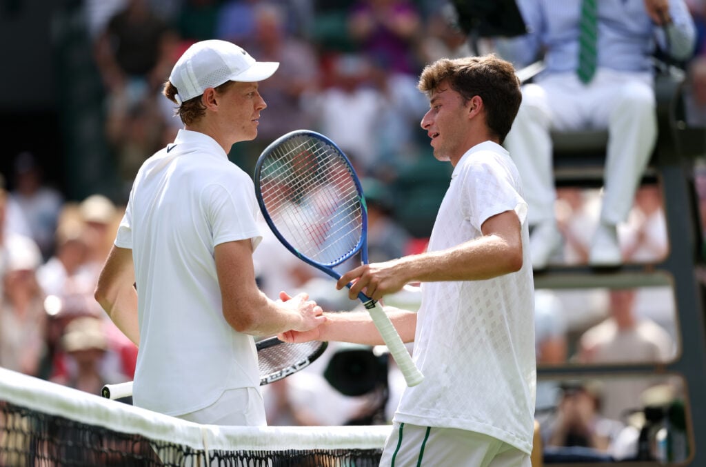 Jannik Sinner shaking Luca Nardi's hand after Wimbledon 2025 victory