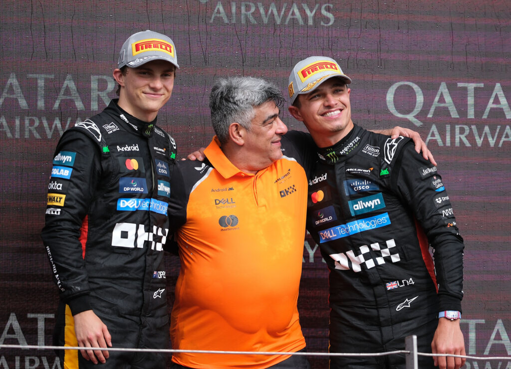 Lando Norris and Oscar Piastri of McLaren F1 Team and technical director Peter Prodromou seen on the podium after the Formula One British Grand Prix at Silverstone