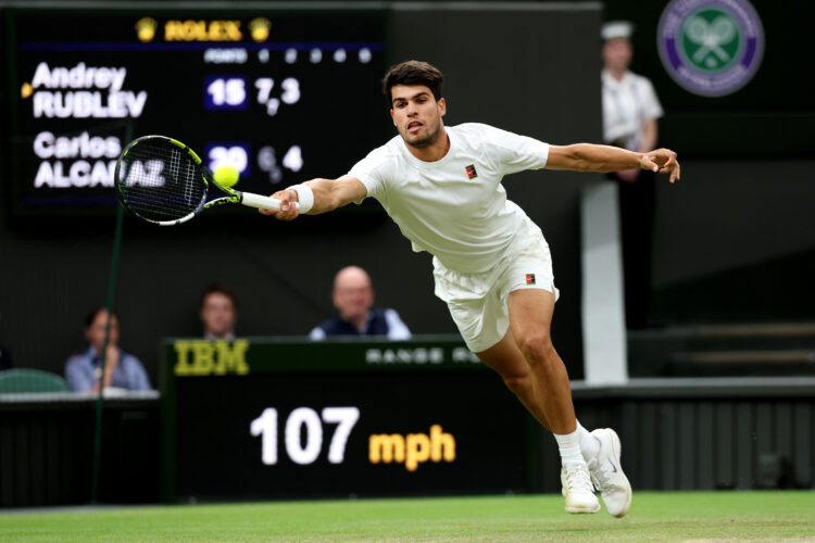 Carlos Alcaraz reaching to make a shot in his fourth round match with Andrey Rublev at Wimbledon