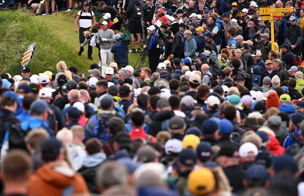 Rory McIlroy of Northern Ireland walks to the 14th fairway in front of a crowd