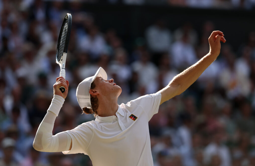 Jannik Sinner hitting a serve against Carlos Alcaraz in the Wimbledon 2025 final