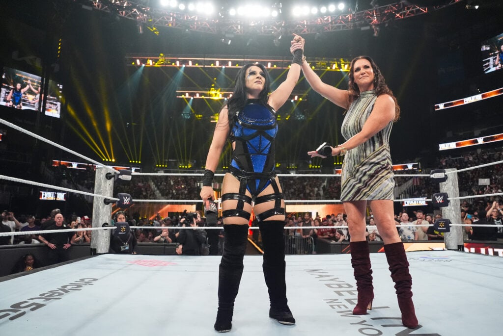 Stephanie McMahon lifting Stephanie Vaquer's arm after she won the WWE Evolution Battle Royal