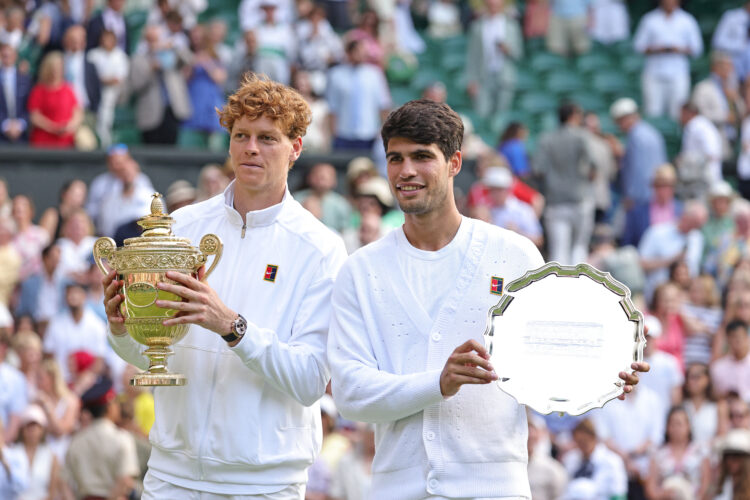 Jannik Sinner and Carlos Alcaraz showing off their Wimbledon trophies after the 2025 final