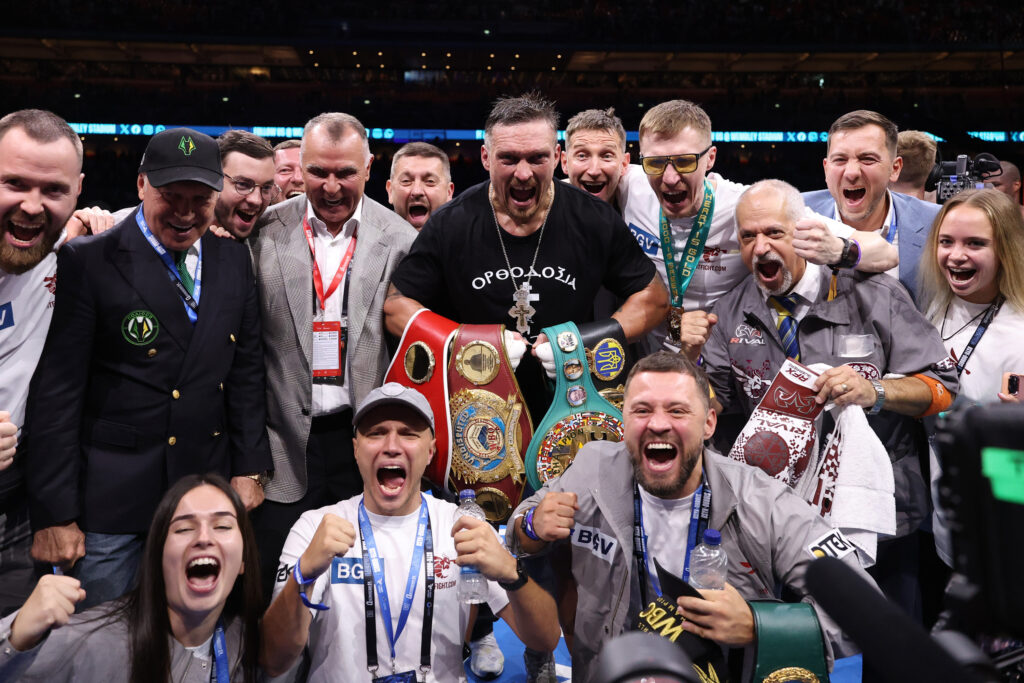 Oleksandr Usyk celebrates winning belts with his team