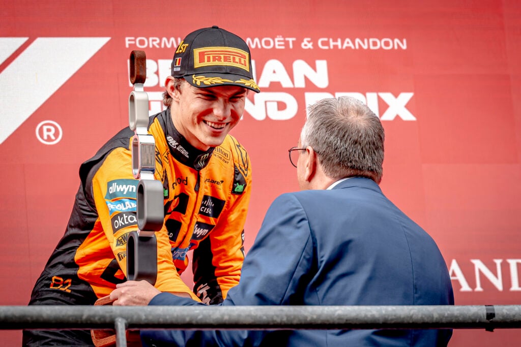 Oscar Piastri receives his trophy atop the podium after winning the Belgian Grand Prix for McLaren.