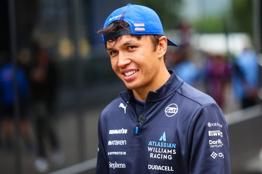 Williams driver Alex Albon looks on in the paddock