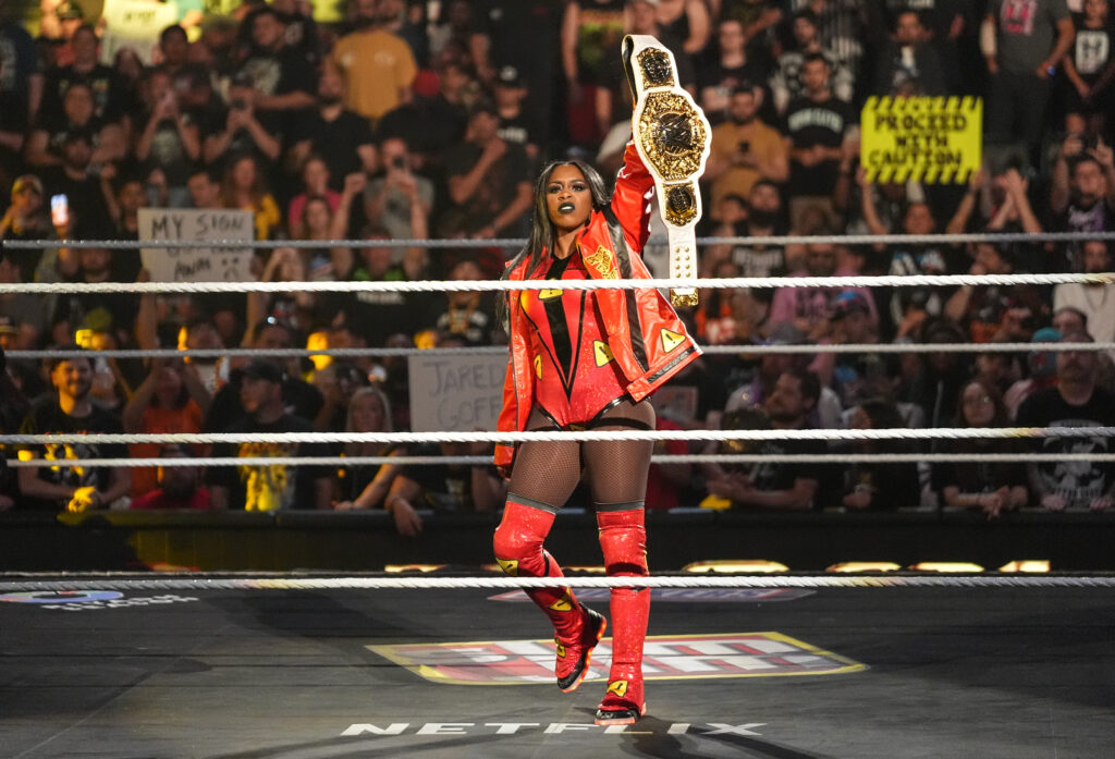 Naomi holding alift the Women's World Championship on WWE Monday Night RAW