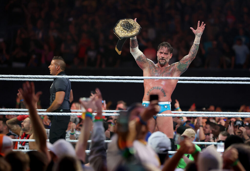 CM Punk holding the World Heavyweight Championship aloft at WWE SummerSlam