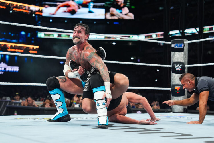 CM Punk hitting Gunther with the Sharpshooter at WWE SummerSlam