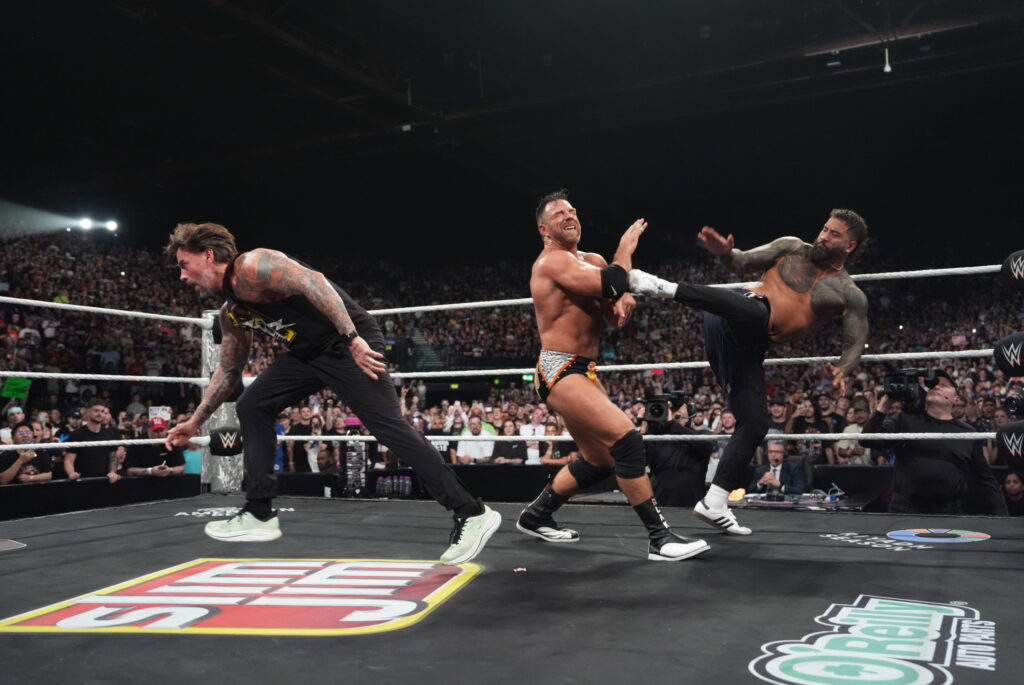 Jey Uso hitting LA Knight with a Superkick with CM Punk in the background on WWE Monday Night RAW