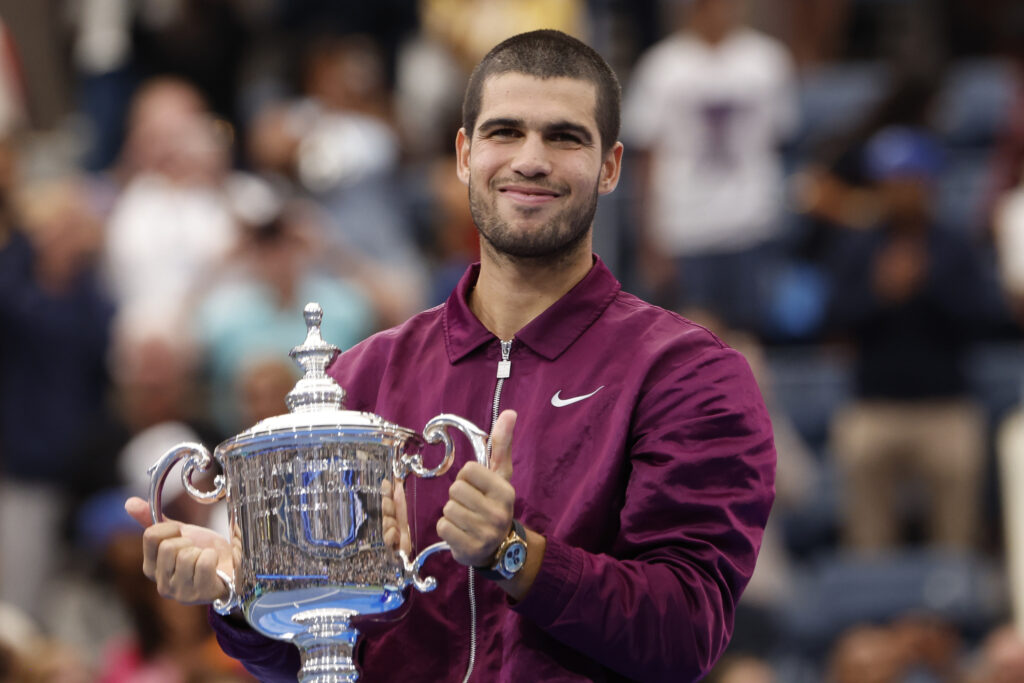 Carlos Alcaraz lifting the 2025 US Open trophy after defeating Jannik Sinner