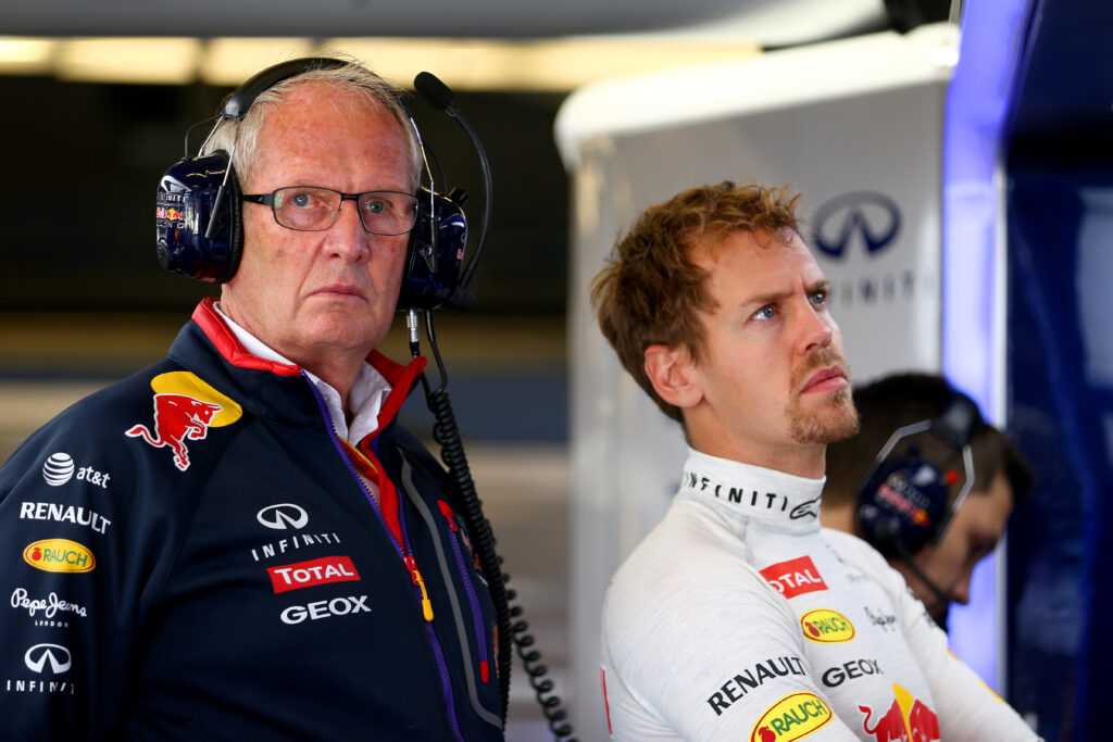Sebastian Vettel and Helmut Marko stand together in the Red Bull Racing garage during practice for the 2014 Formula 1 Grand Prix in Texas.