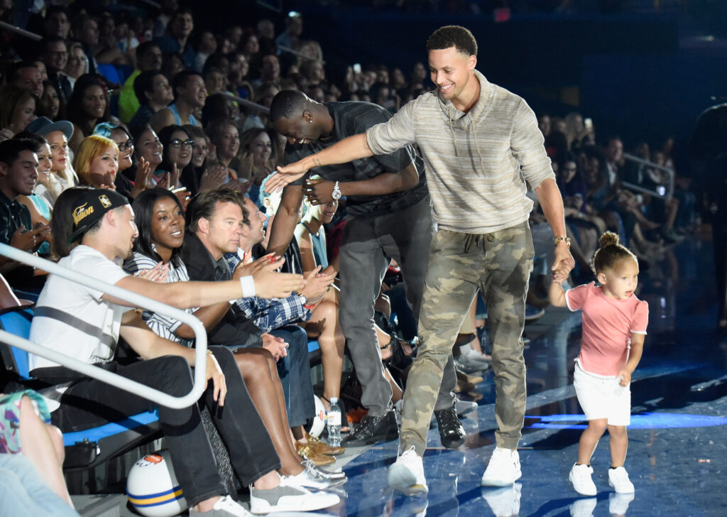 Stephen Curry (center) walks onstage to accept the Best Male Athlete Award with Riley Curry at the Nickelodeon Kids' Choice Sports Awards 2015