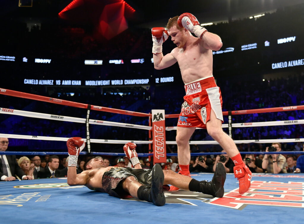 Canelo Alvarez stands over Amir Khan after knocking him to the canvas.
