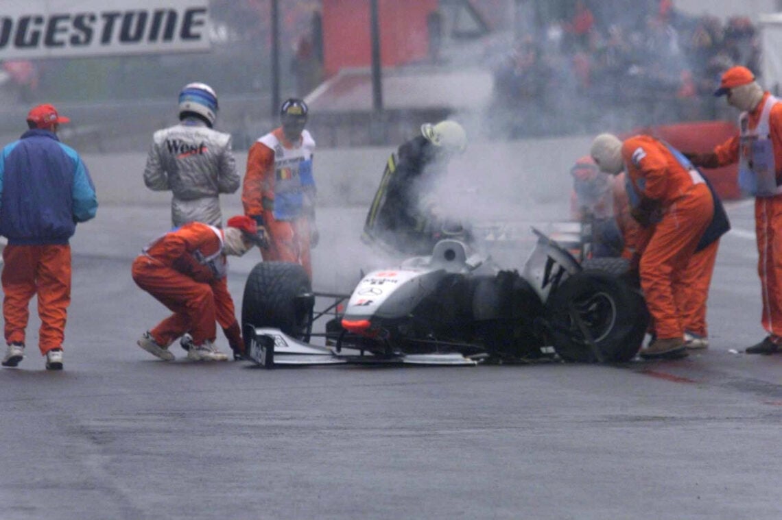 Mikka Häkkinen exits his smoking car at the 1998 Belgian Grand Prix.